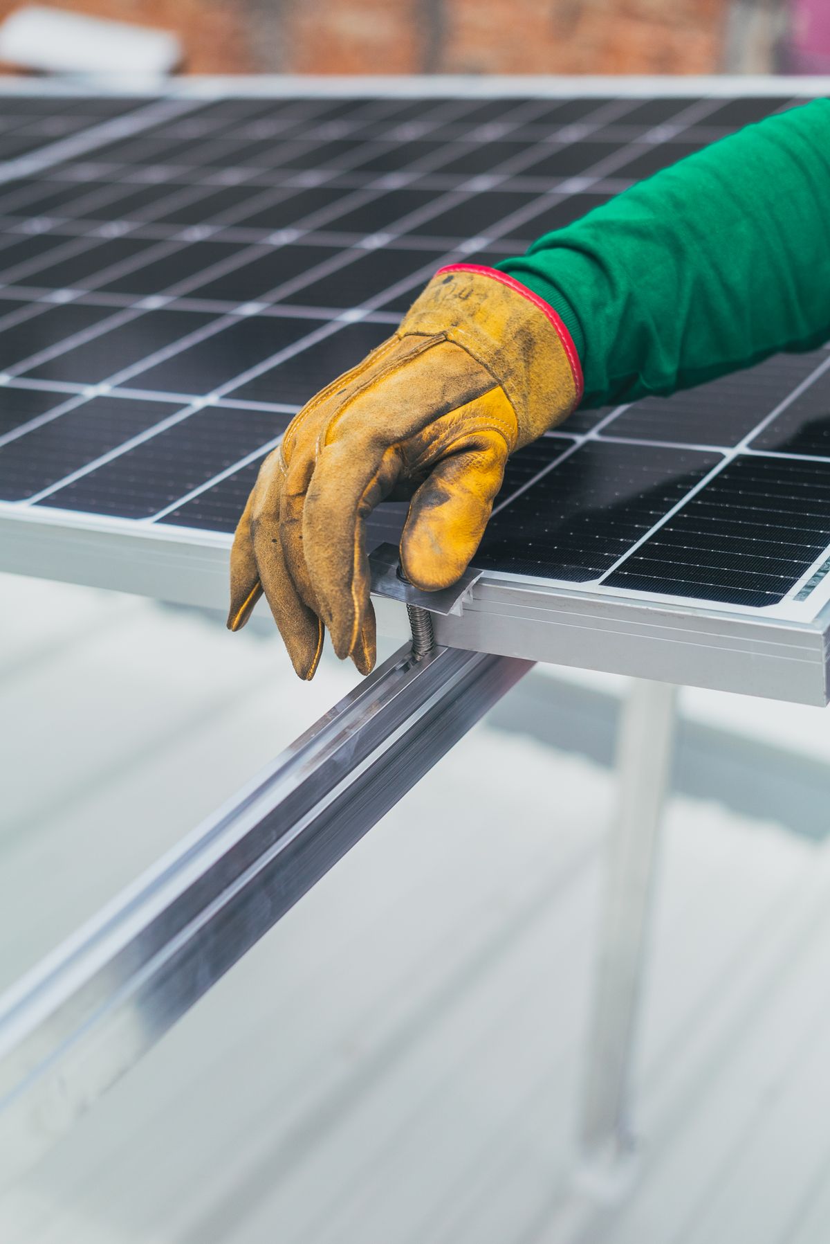 Gloved hands aligning a solar panel during installation