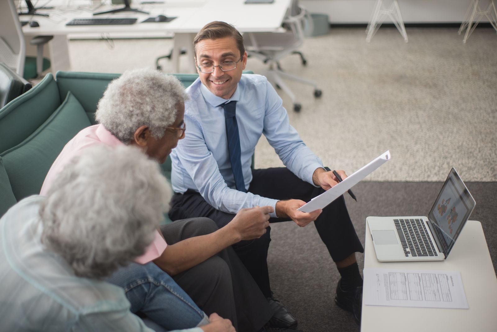 Insurance advisor reviewing a policy with a couple at their kitchen table